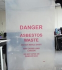 La basura grande del Biohazard empaqueta palabras del peligro imprimió la eliminación de desechos del amianto